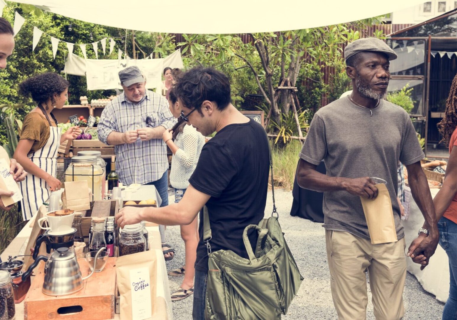 Outdoor market scene with people buying coffee.